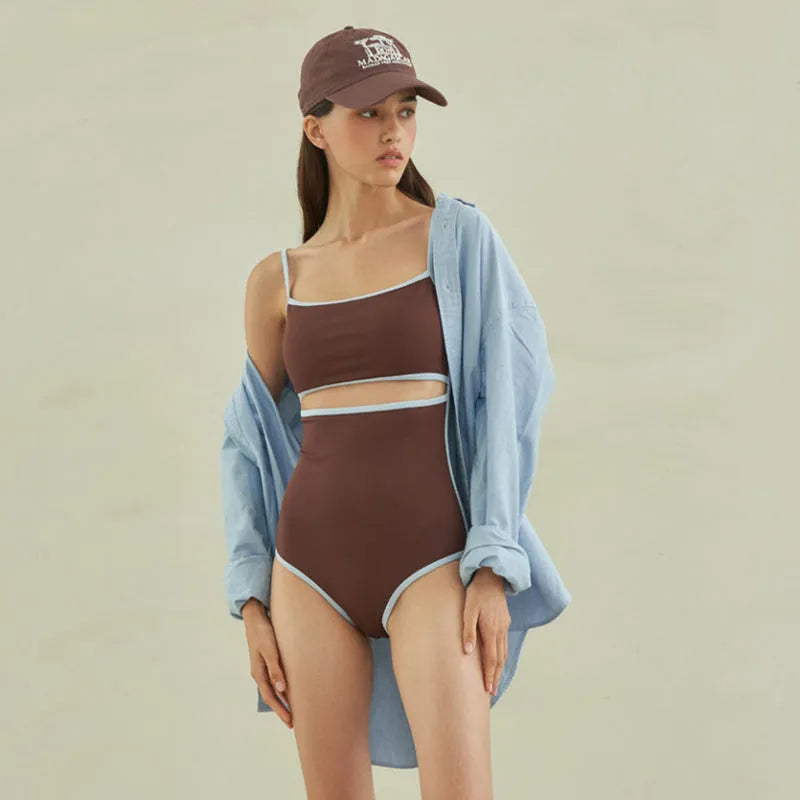 Brown women's one-piece swimsuit with triangle neckline on a hanger.