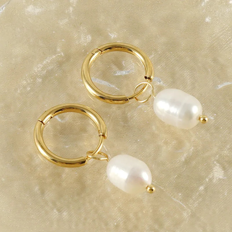 A pair of gold-coloured geometric earrings with a central pearl, made from stainless steel.