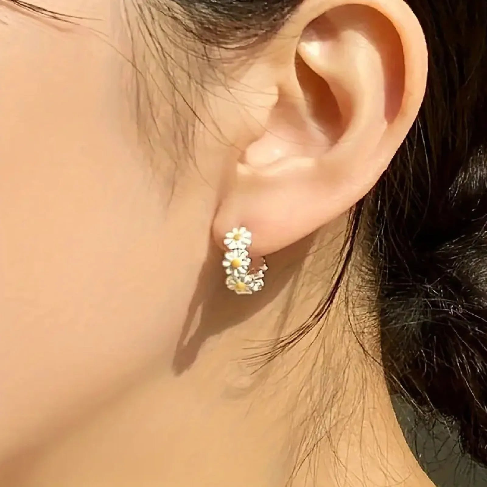 White electroplated daisy flower ring earrings with platinum gem settings on a copper base.
