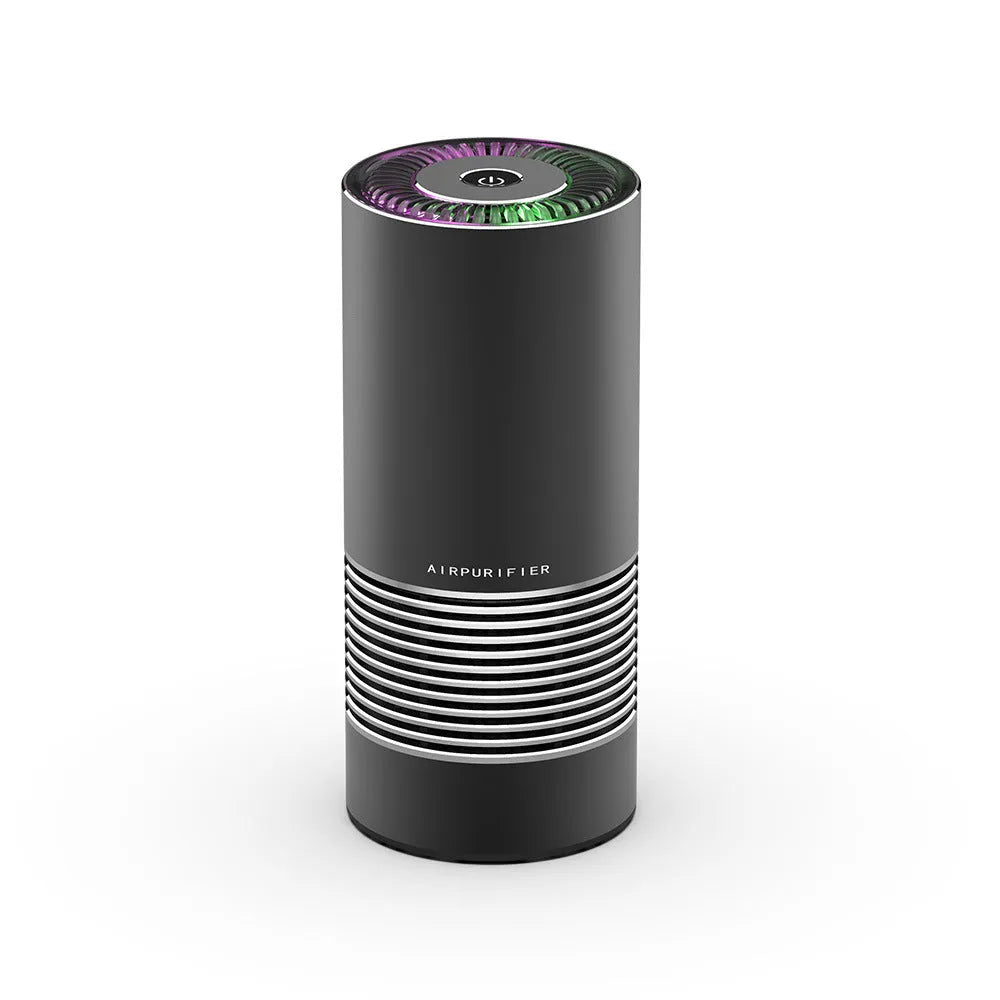Compact cylindrical car air purifier in metallic grey with USB cable, shown next to a car vent for scale.