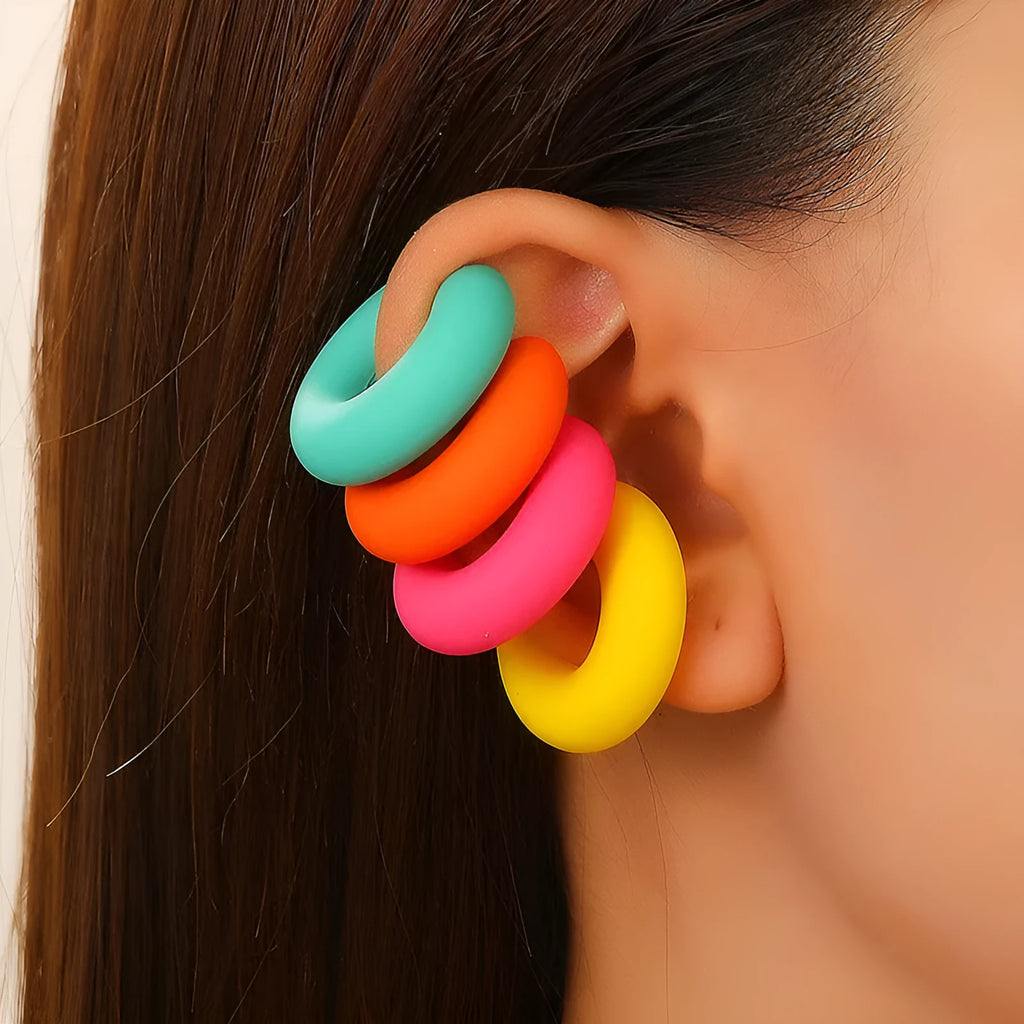 Geometric round C-shaped clip-on earrings in a matte coarse candy colour on a white background.