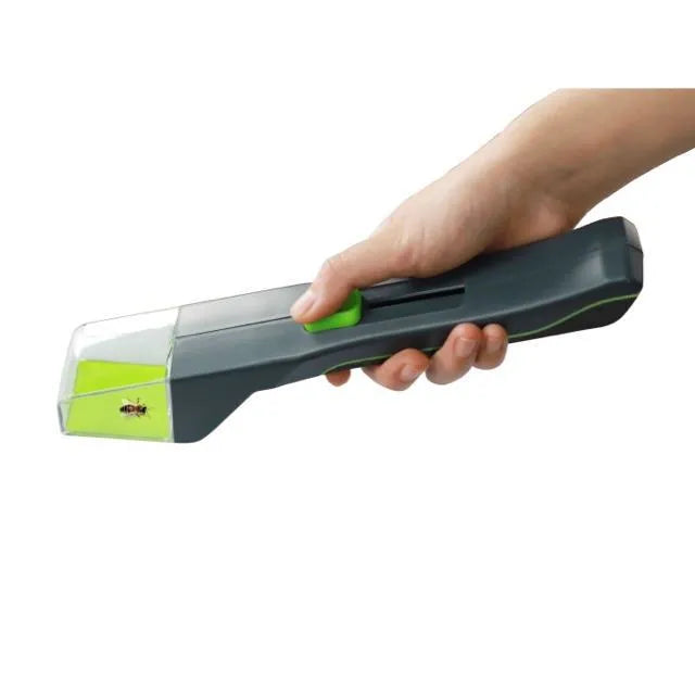 Green plastic handheld insect catcher for garden pest control on lawn