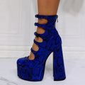 Women's black patent leather platform high heel boots with a serpentine belt and buckle closure.