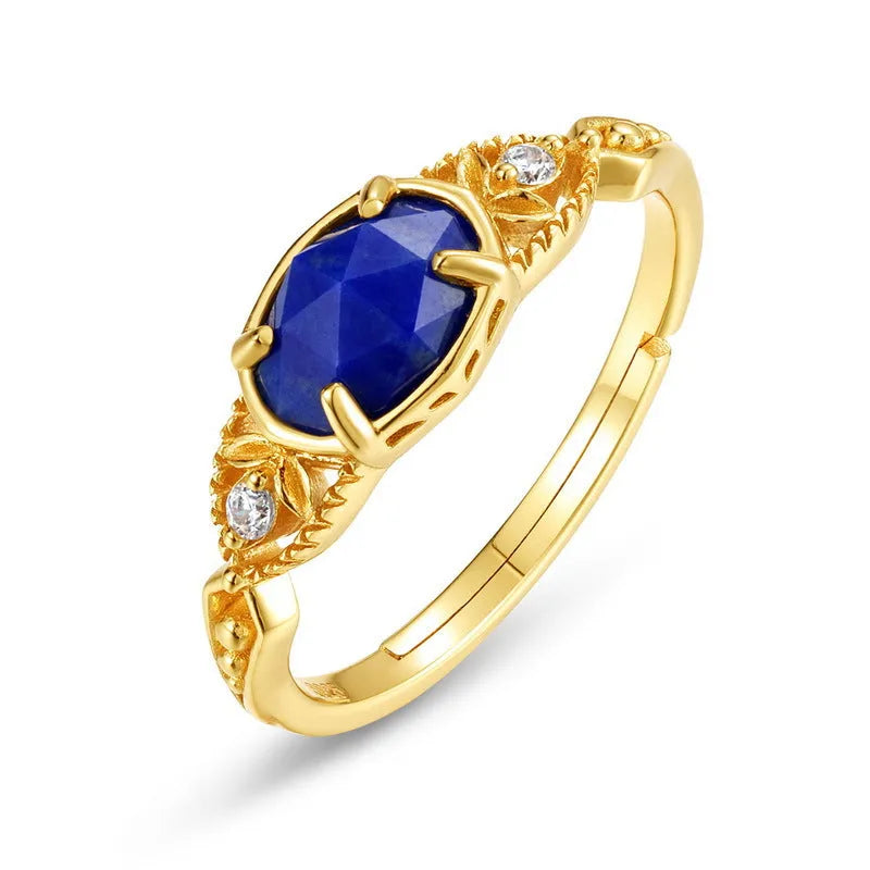 Close-up of a silver elliptical ring with a deep blue lapis lazuli stone set in a geometric band.