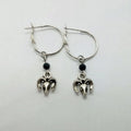 A pair of silver-coloured round hoop earrings with a detailed Tibetan antelope design.