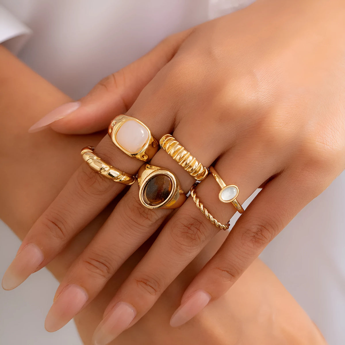 Six geometric alloy rings with light gold electroplated finish arranged in set