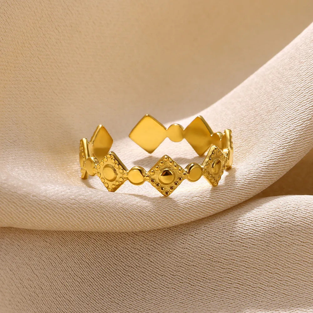 Gold diamond geometric titanium steel ring for women on a plain background