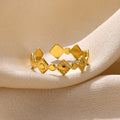 Gold diamond geometric titanium steel ring for women on a plain background