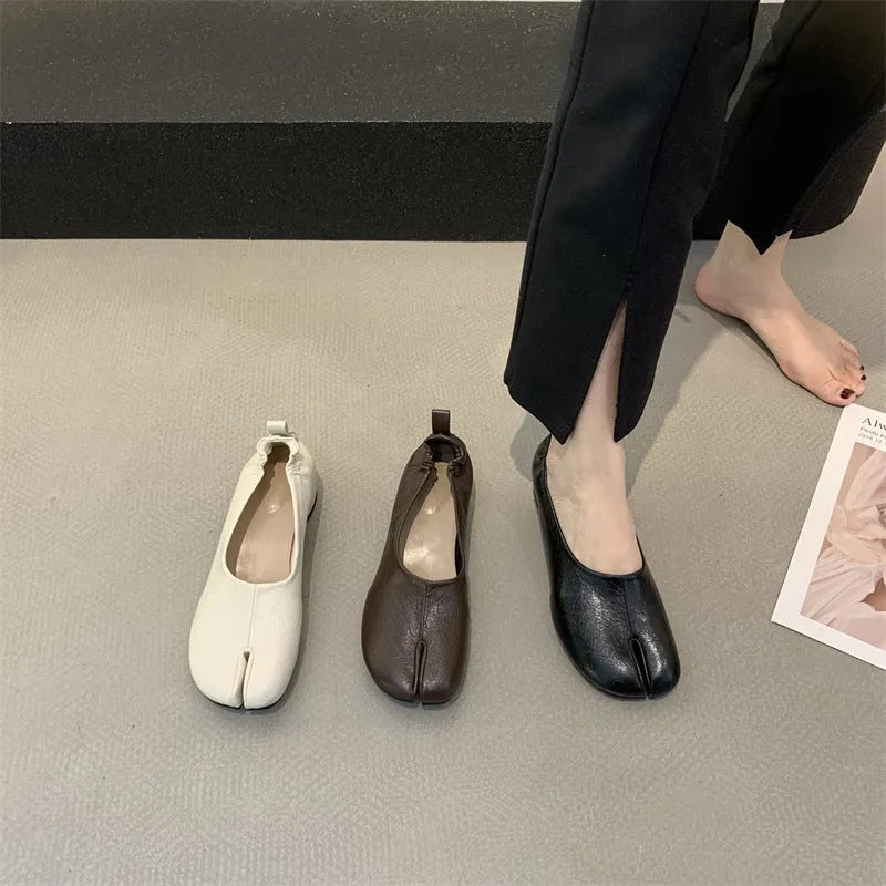 Women's black split toe chunky heel pumps with a round toe and low heel on a rubber sole.