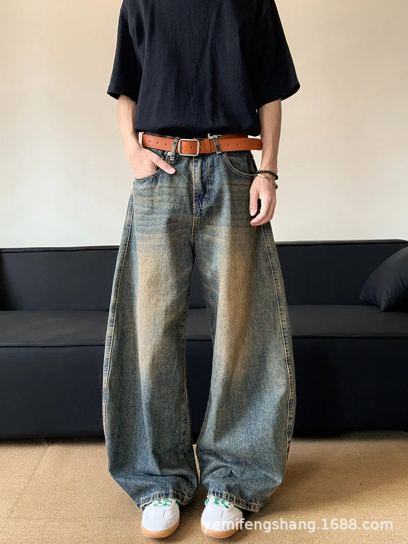 Men modelling retro blue distressed wide-leg jeans with machete detailing and a slimming fit.