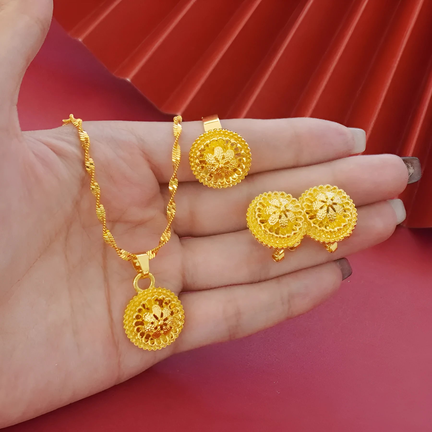 Gold plated three-piece jewellery set with floral pendant, matching earrings and ring