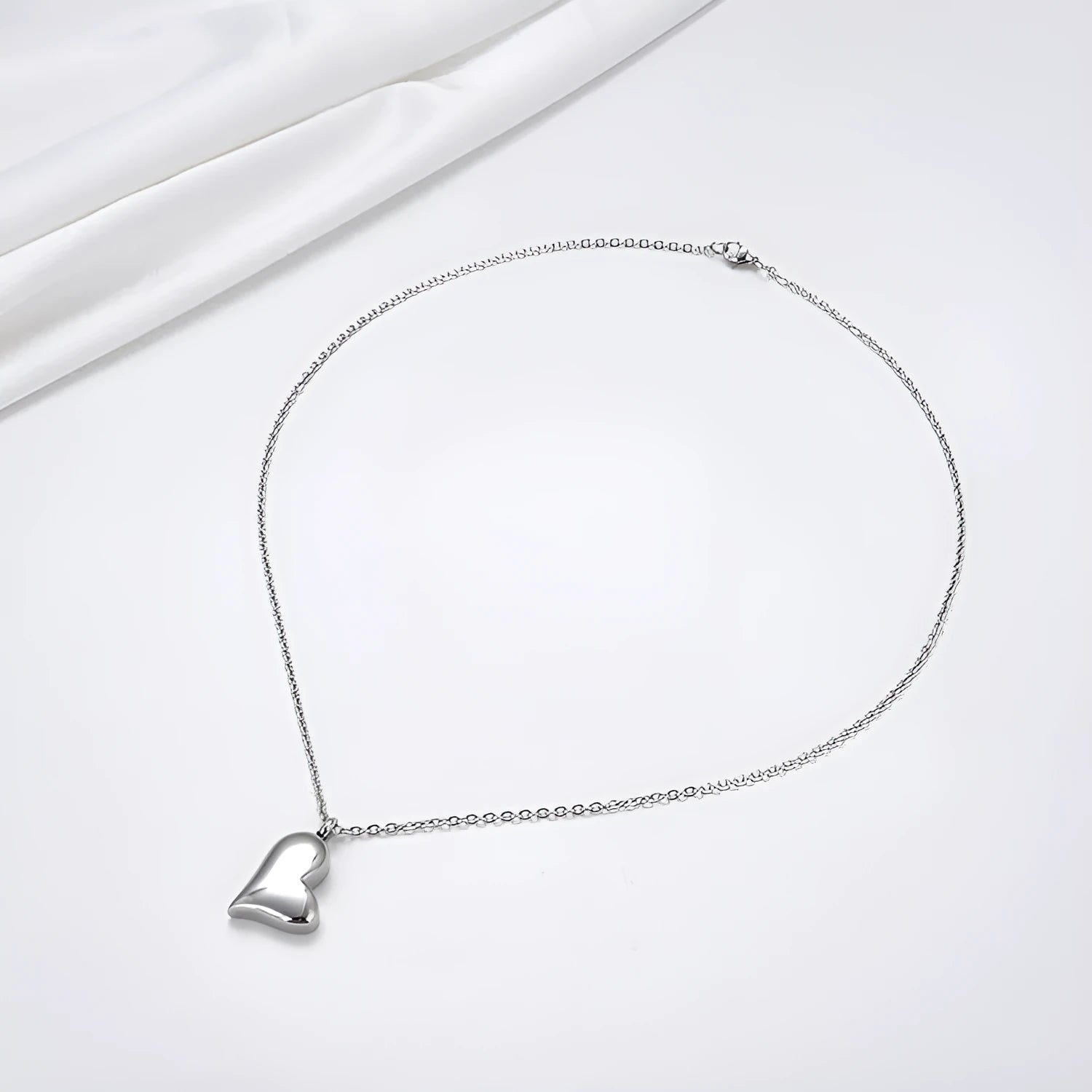 Silver curved peach heart pendant on a stainless steel necklace chain
