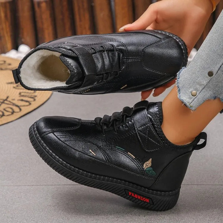 Women's black velvet slippers with a low-cut socks design and a light-coloured rubber sole.