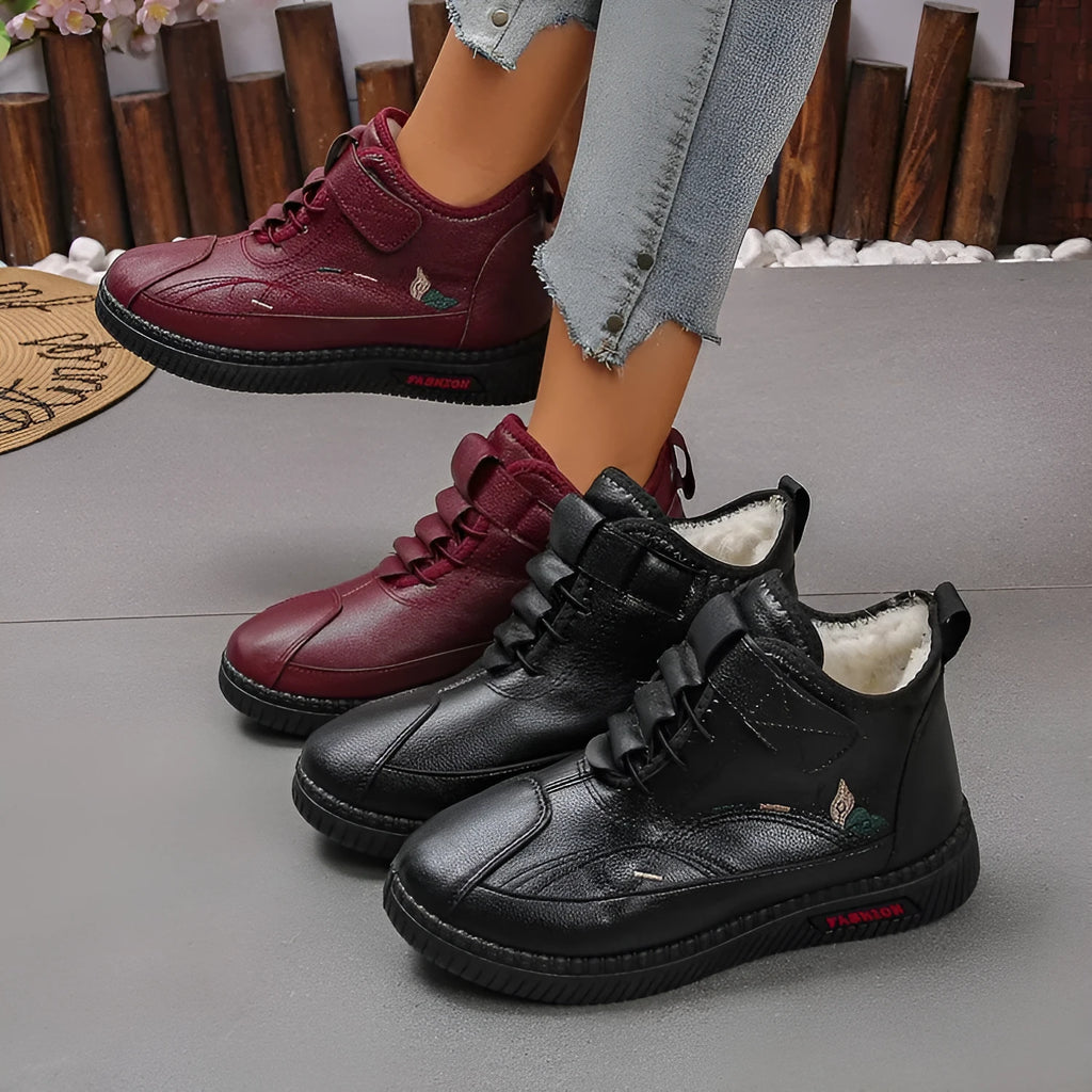 Women's black velvet slippers with a low-cut socks design and a light-coloured rubber sole.