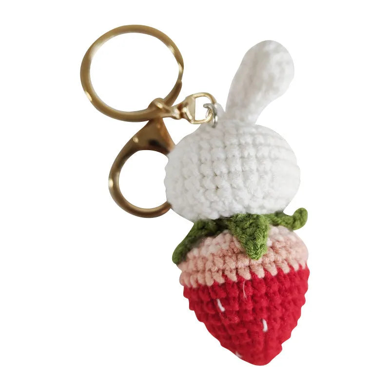 White hand-woven wire pendant with a rabbit and strawberry design on a key ring