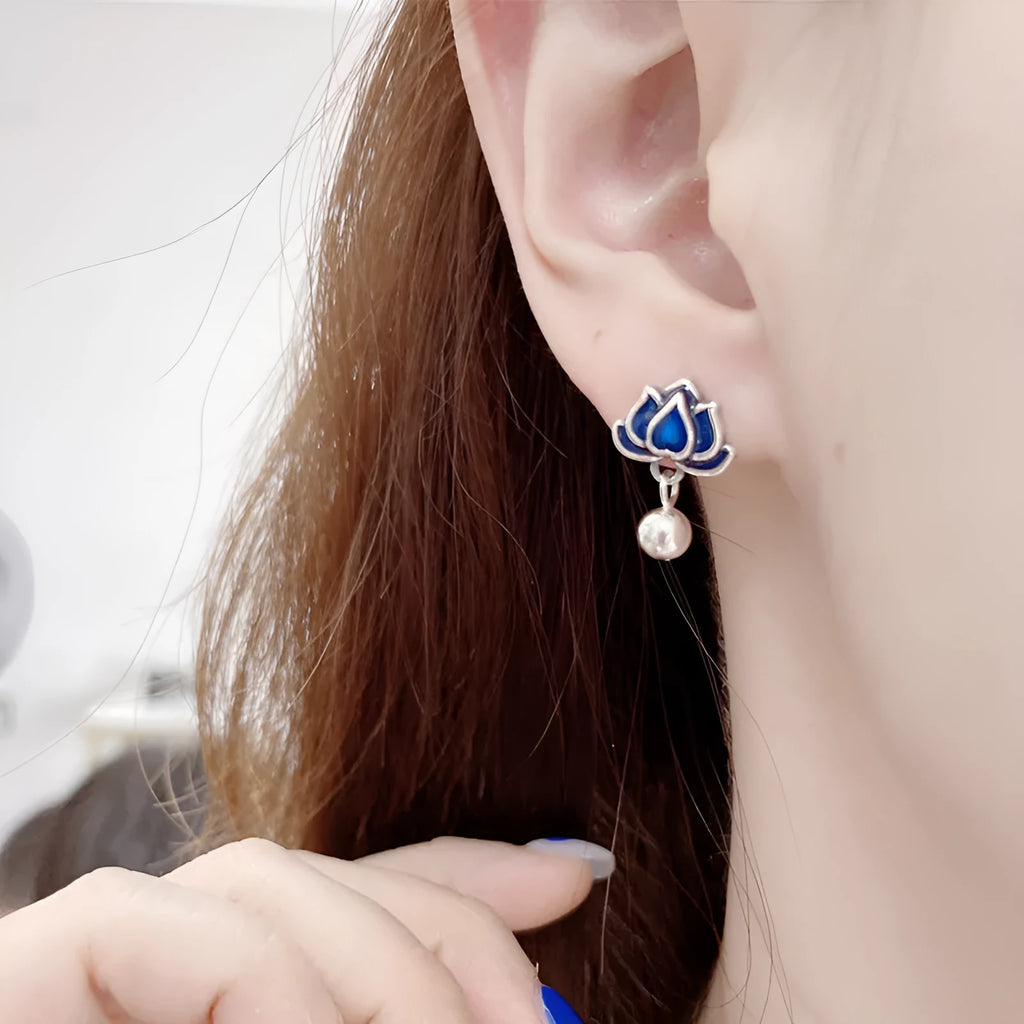 Blue alloy lotus flower stud earrings with a dangling seedpod tassel on silver posts.