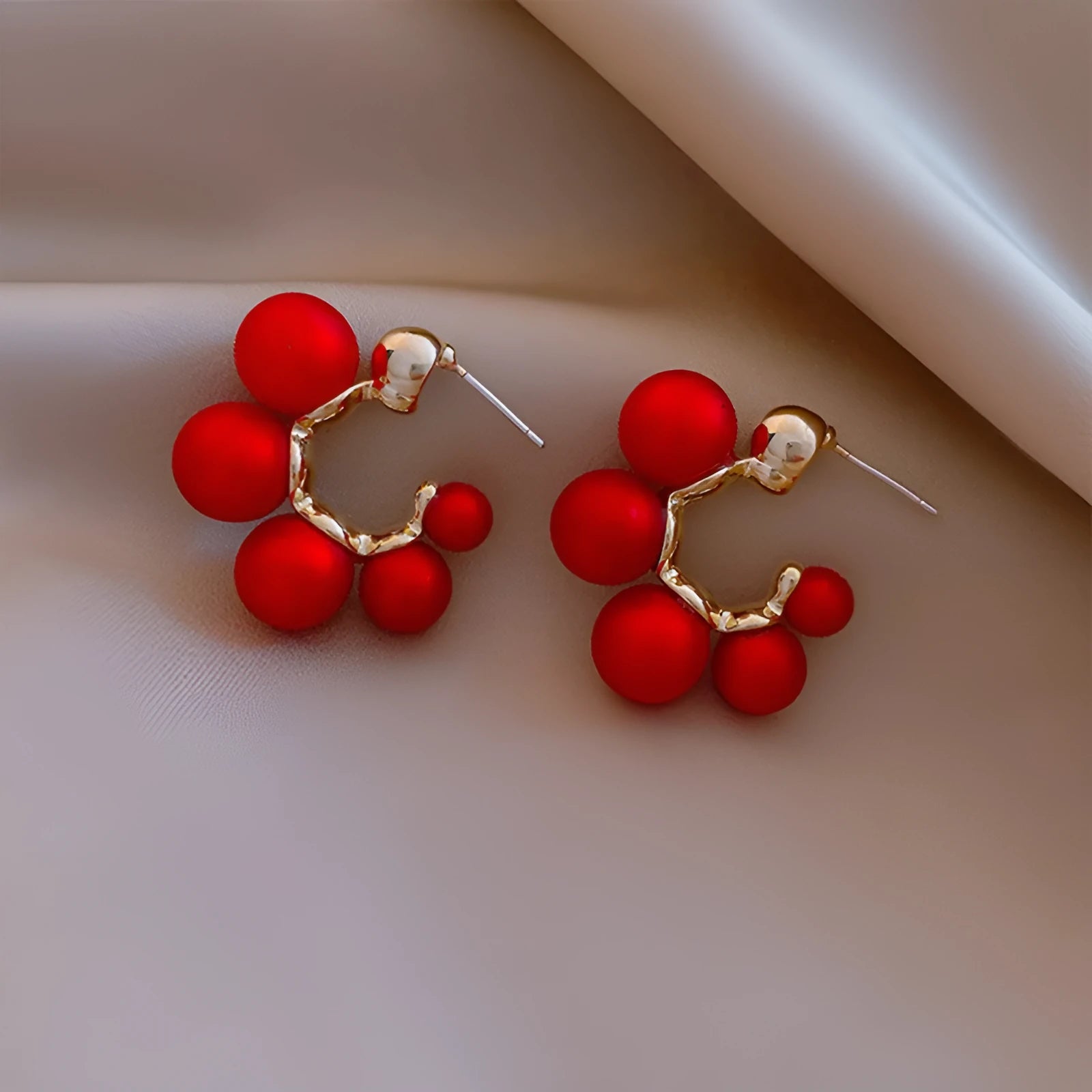 A pair of red bell-shaped alloy earrings for women on a white background.