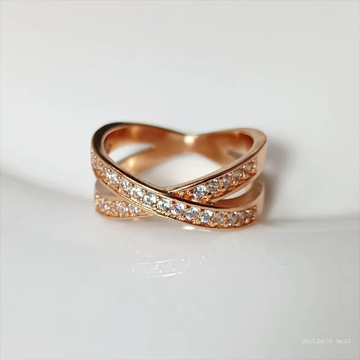 Silver and rose gold cross ring with micro-inlaid zircon stones on a simple geometric band.