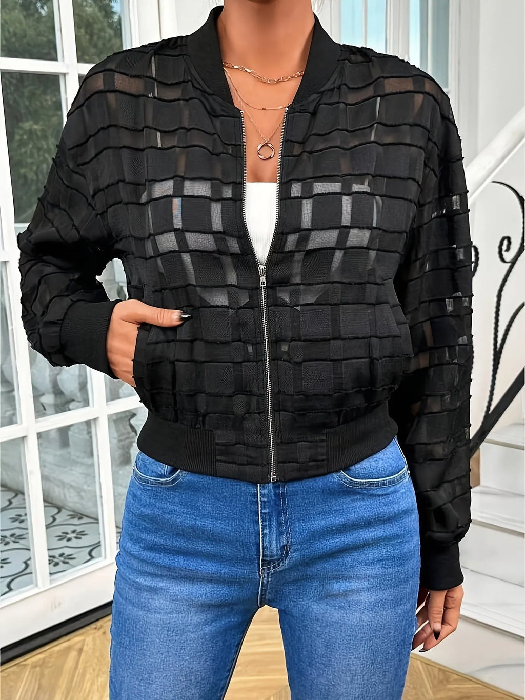 Black women's casual jacket with geometric pattern, full zip, and long sleeves on a hanger.