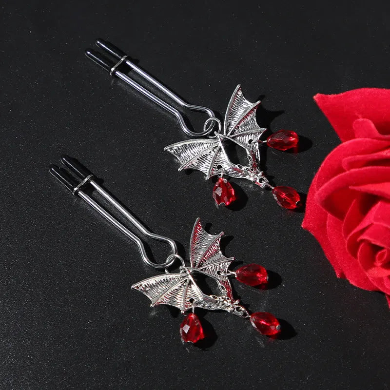 Silver bat-shaped nipple clamps with ruby accents and adjustable pressure mechanism