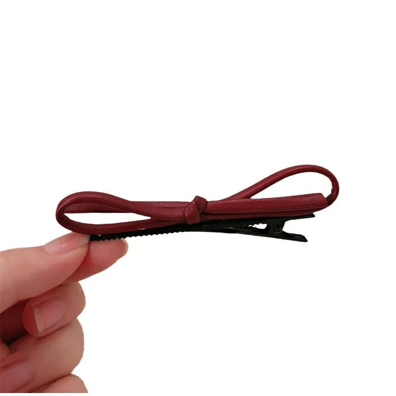 Wine red leather bow hair barrettes showing bow detail and clip mechanism