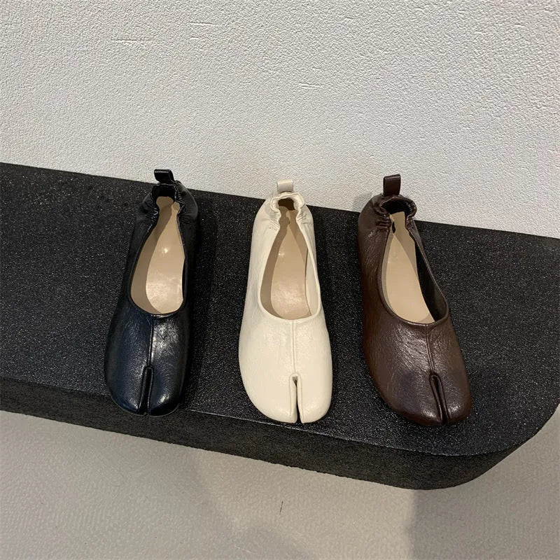 Women's black split toe chunky heel pumps with a round toe and low heel on a rubber sole.