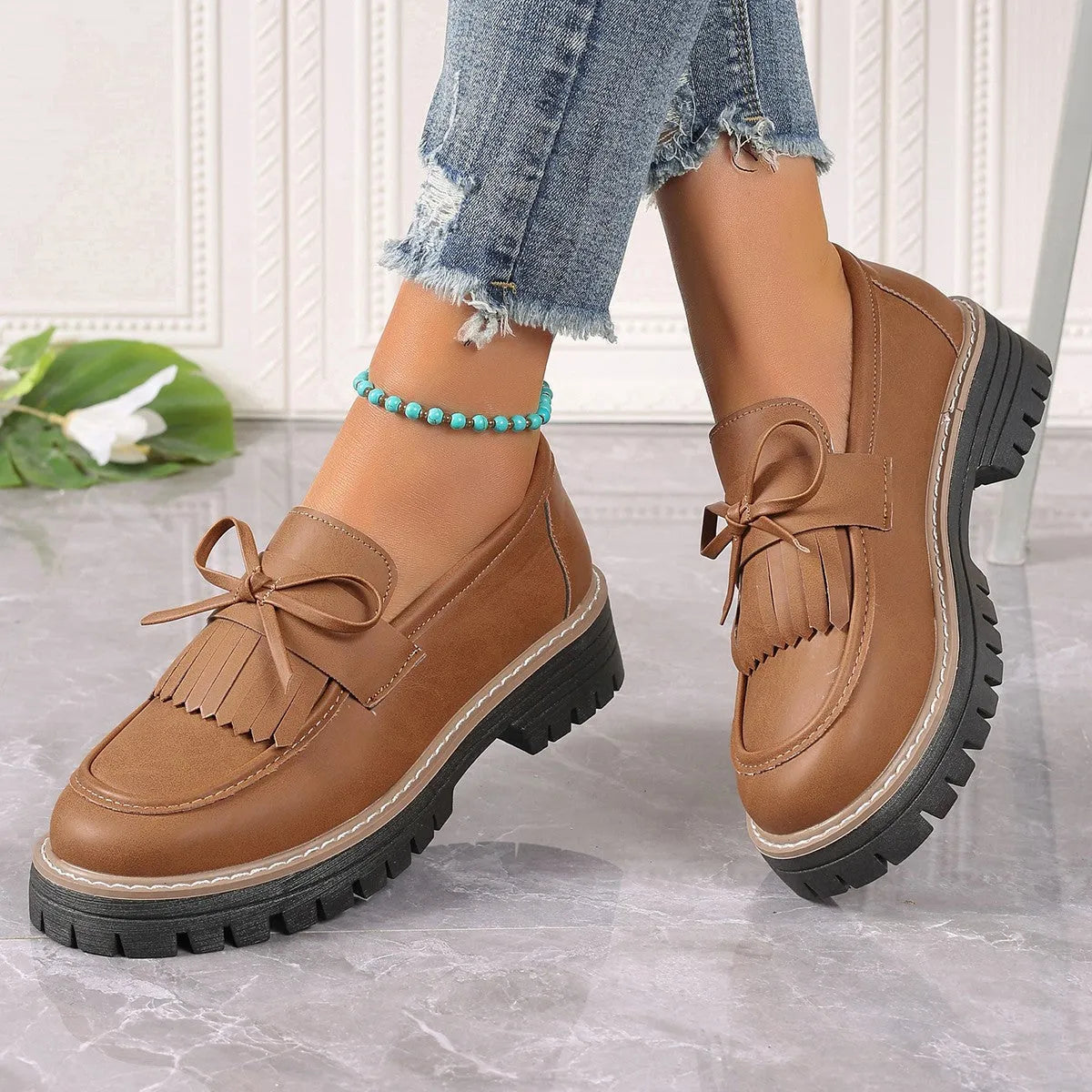 Plus size black loafers for women with a tassel bowknot and chunky low heel.