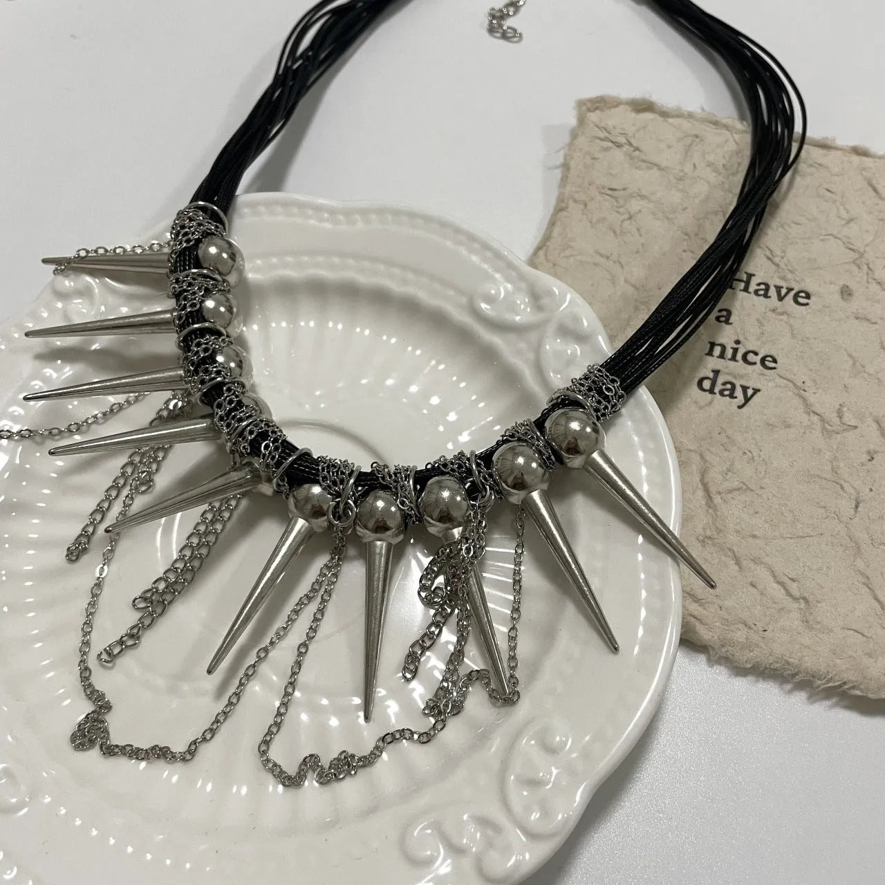 Women's leather necklace with winding tassel, round beads, and metal rivet details