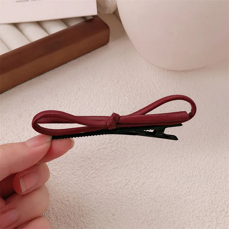 Wine red leather bow hair barrettes showing bow detail and clip mechanism