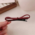 Wine red leather bow hair barrettes showing bow detail and clip mechanism