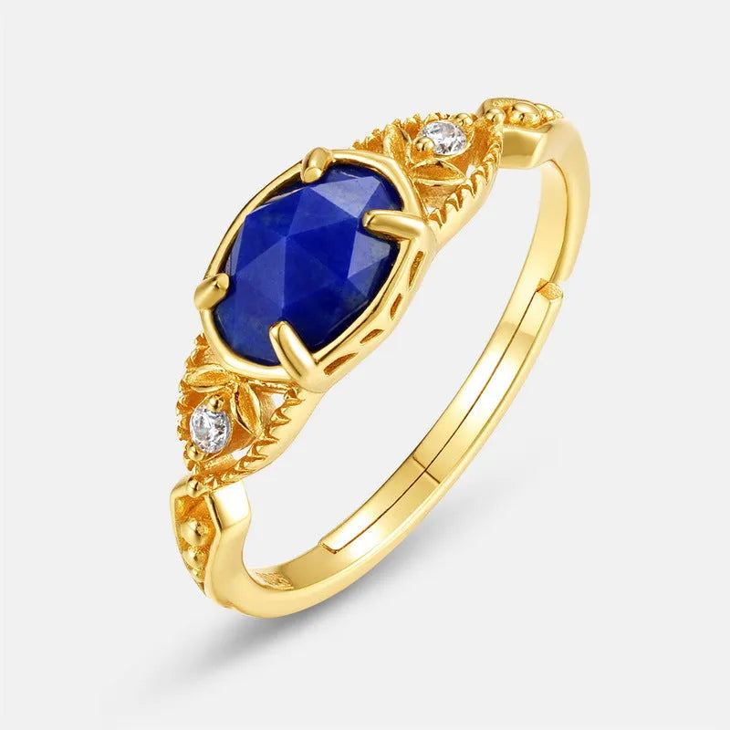 Close-up of a silver elliptical ring with a deep blue lapis lazuli stone set in a geometric band.