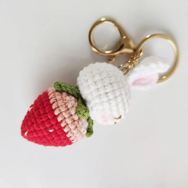 White hand-woven wire pendant with a rabbit and strawberry design on a key ring