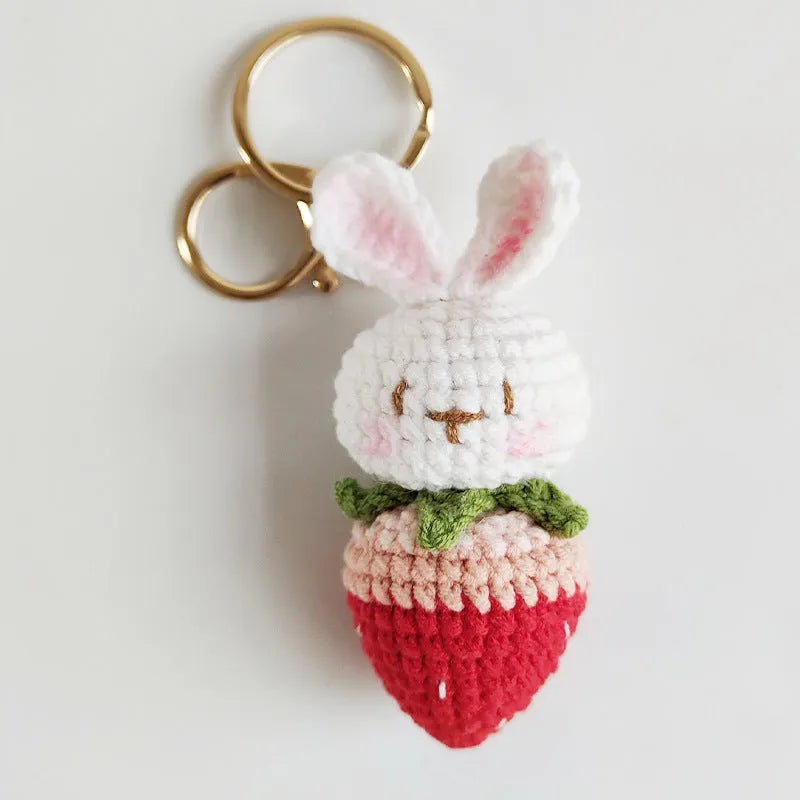 White hand-woven wire pendant with a rabbit and strawberry design on a key ring