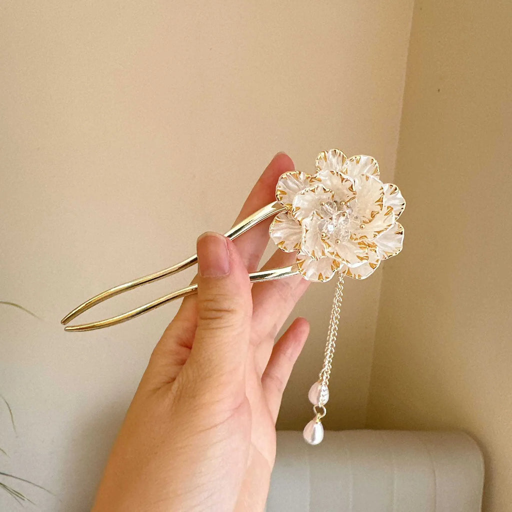 Close-up of a purple U-shaped alloy hairpin with a peony flower and tassel decoration.