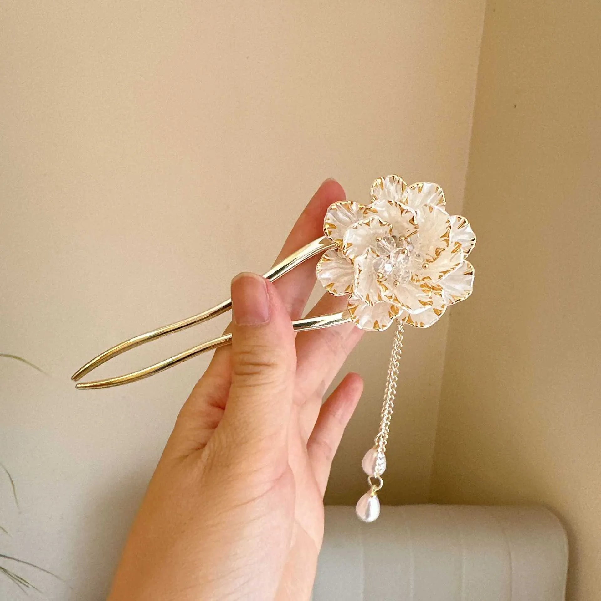 Close-up of a purple U-shaped alloy hairpin with a peony flower and tassel decoration.