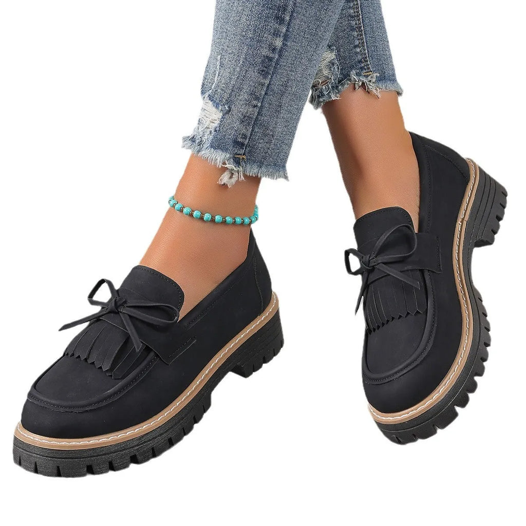 Plus size black loafers for women with a tassel bowknot and chunky low heel.