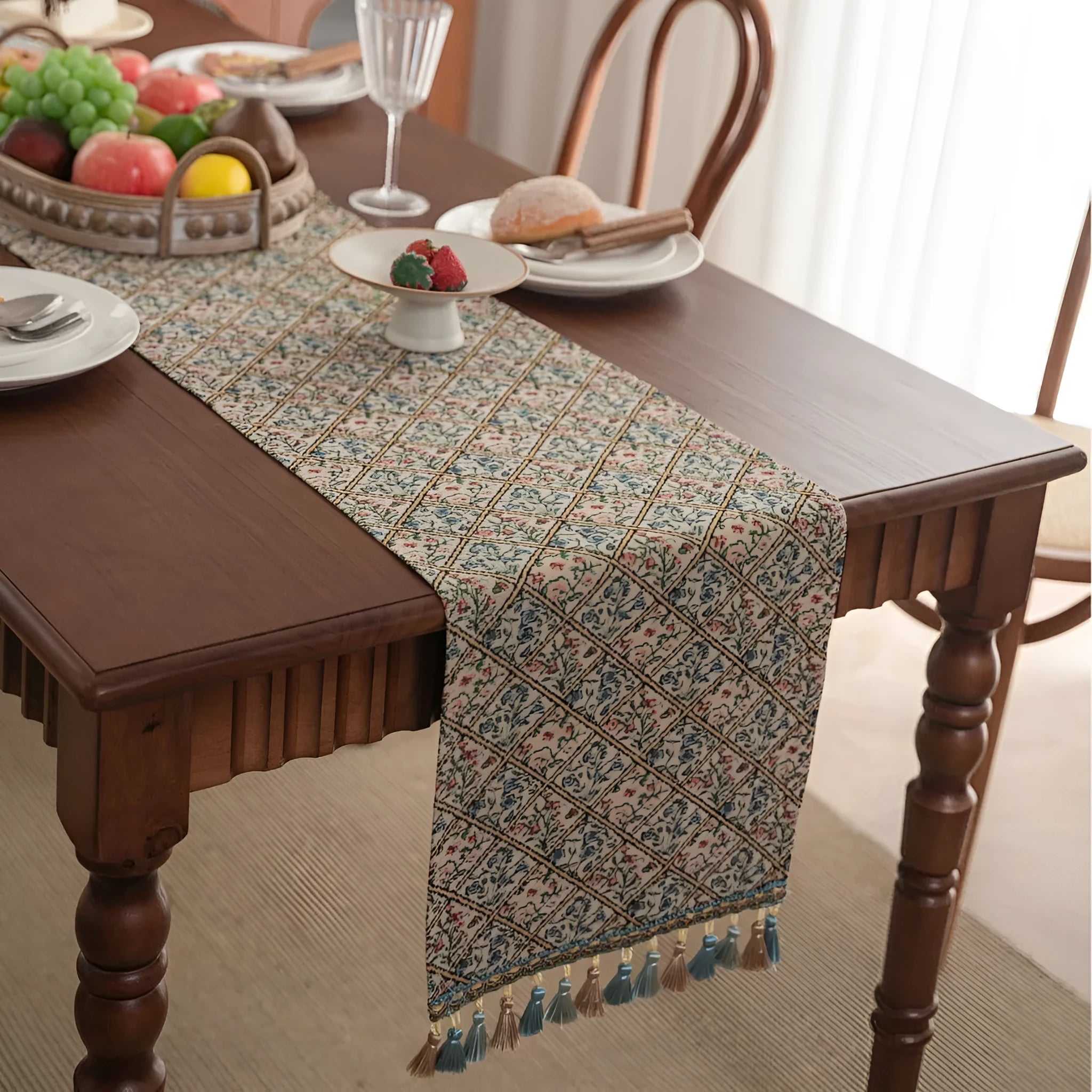 Dark blue striped table runner with jacquard bouquet pattern and tassel ends on a wooden table.