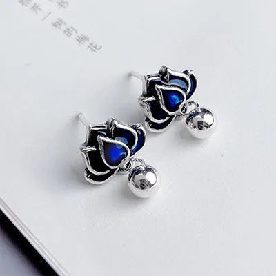 Blue alloy lotus flower stud earrings with a dangling seedpod tassel on silver posts.