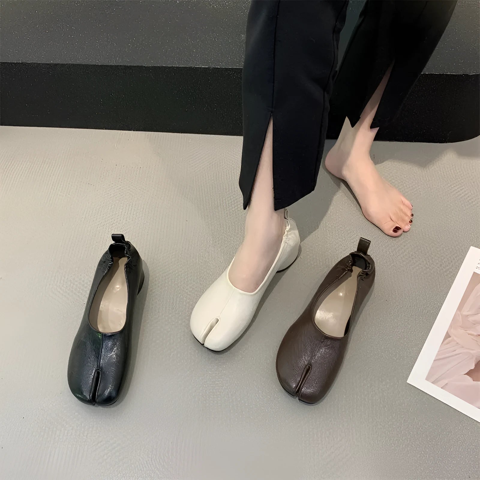 Women's black split toe chunky heel pumps with a round toe and low heel on a rubber sole.