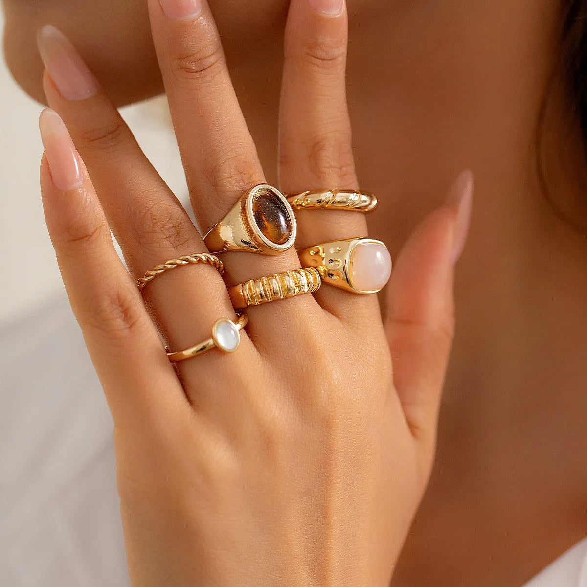 Six geometric alloy rings with light gold electroplated finish arranged in set