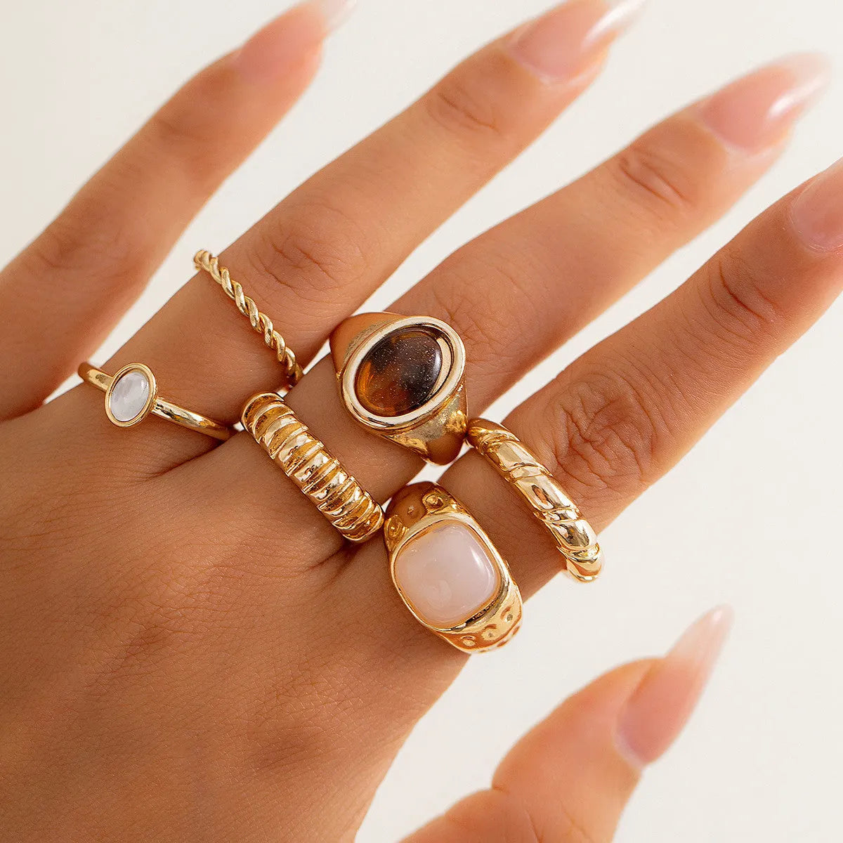 Six geometric alloy rings with light gold electroplated finish arranged in set