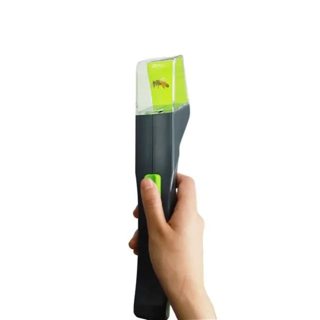 Green plastic handheld insect catcher for garden pest control on lawn