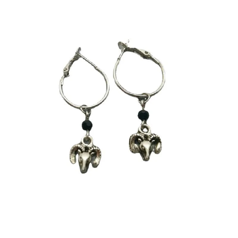 A pair of silver-coloured round hoop earrings with a detailed Tibetan antelope design.