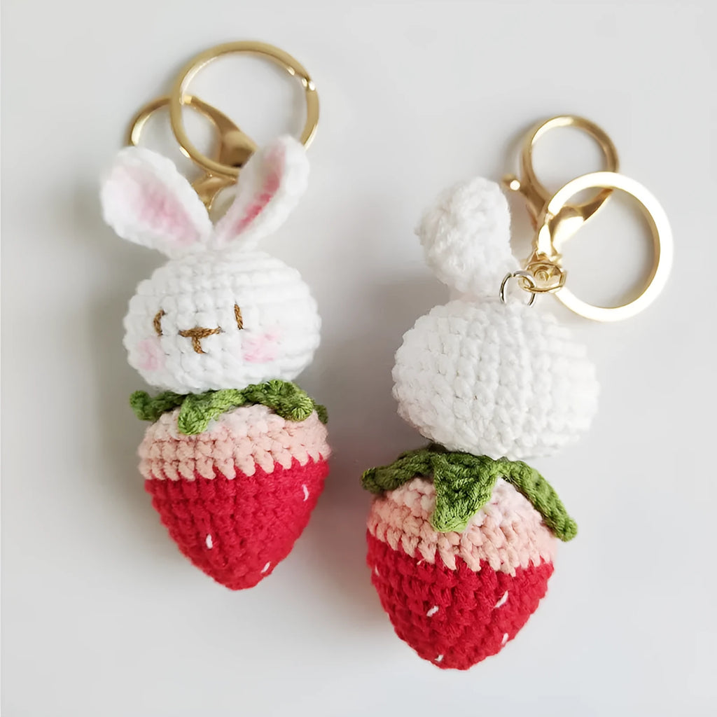 White hand-woven wire pendant with a rabbit and strawberry design on a key ring