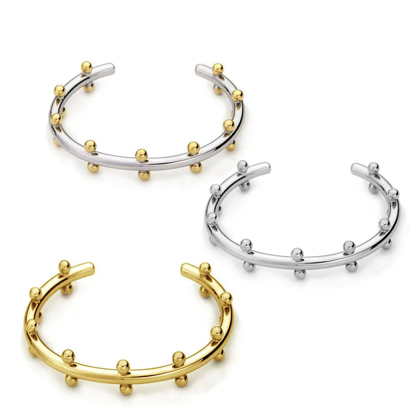 Stainless steel bracelet with textured C-shaped bead links and raised rivet details.
