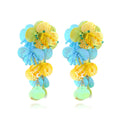 Close-up of handmade colourful string bead flower and leaf earrings in exaggerated dopamine style.