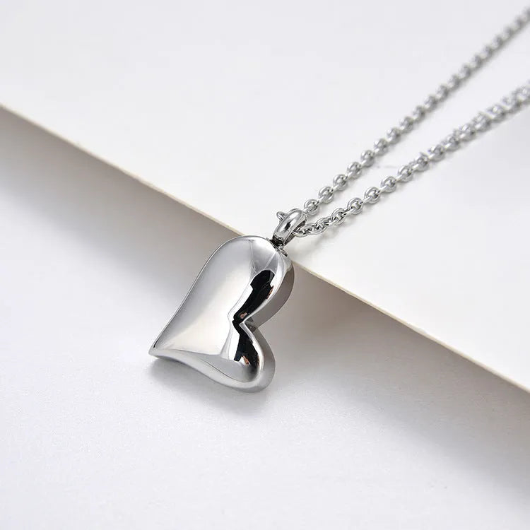 Silver curved peach heart pendant on a stainless steel necklace chain