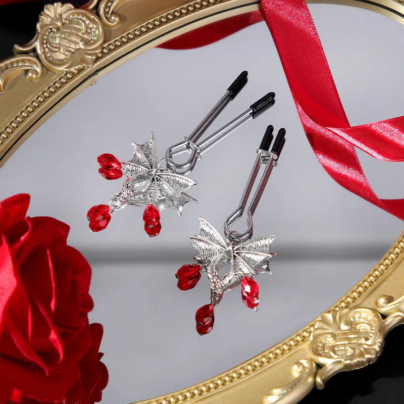 Silver bat-shaped nipple clamps with ruby accents and adjustable pressure mechanism