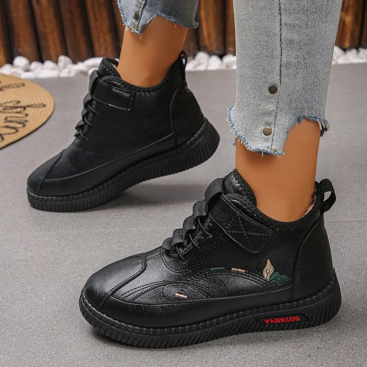 Women's black velvet slippers with a low-cut socks design and a light-coloured rubber sole.