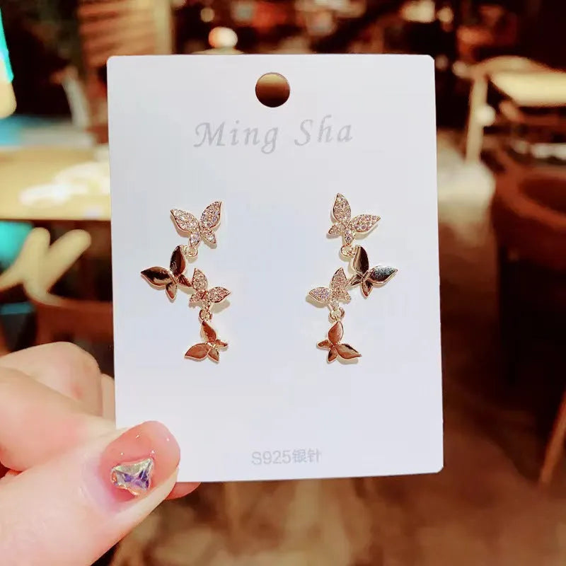 Women's gold tone copper butterfly drop earrings with four butterfly designs